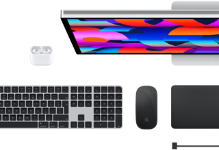 Top view of select Mac accessories: Studio Display, Magic Keyboard, Magic Mouse, Magic Trackpad, AirPods, and MagSafe charging cable